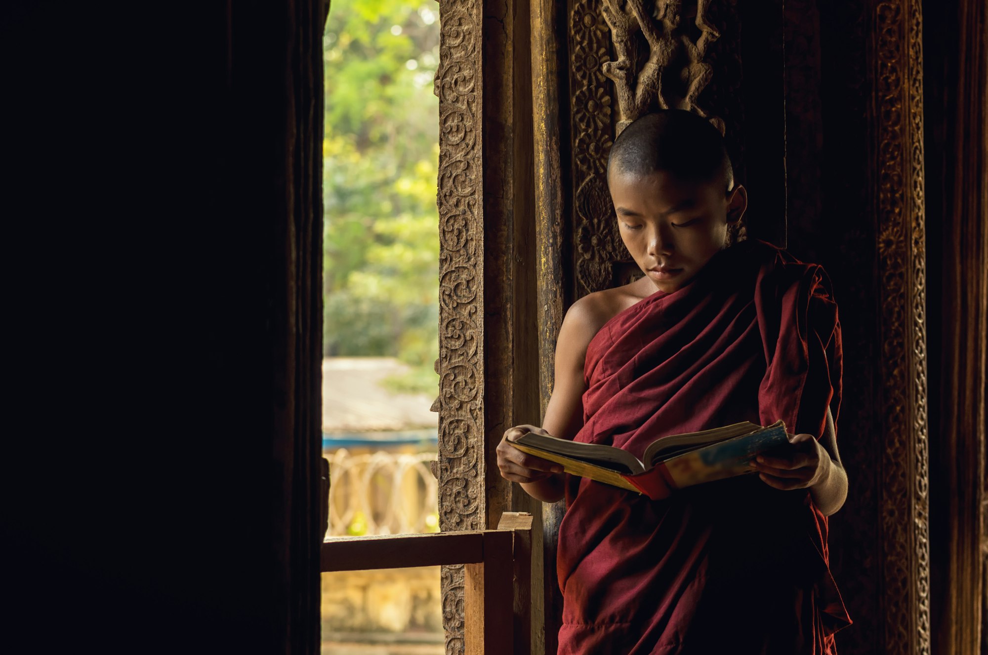 Closeup Buddhist novice reading at Shwenandaw pagoda, mandalay, myanmar